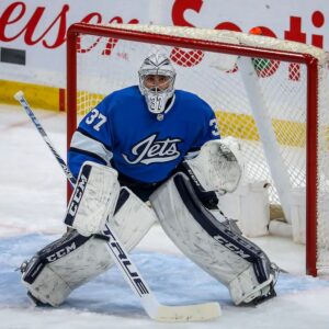 Connor Hellebuyck Winnipeg Jets Unsigned Alternate Jersey in Net Photograph